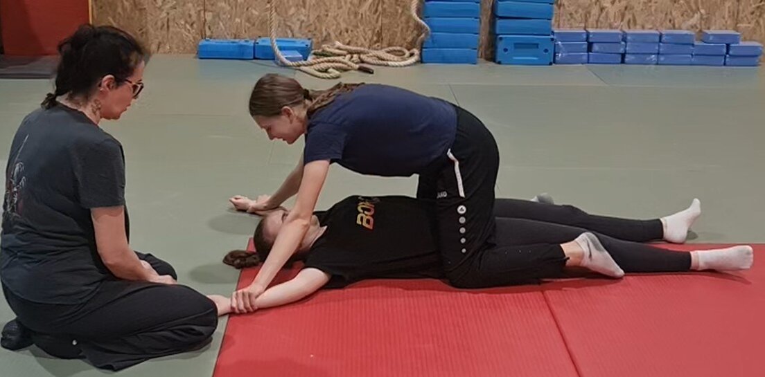 Corso di difesa personale con istruttore e adulti in palestra