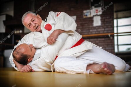 Maestro anziano di judo che dimostra una tecnica di proiezione leggera